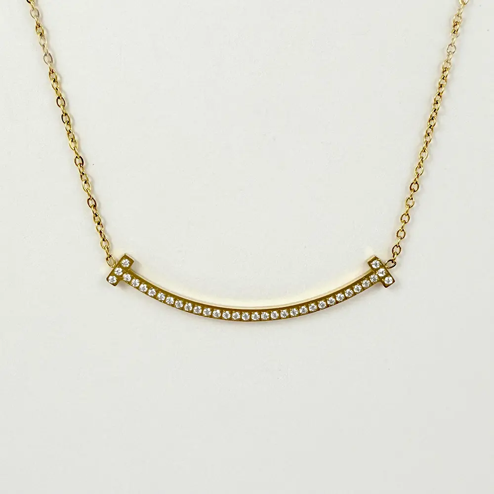 Collar en acero gold dije sonrisa microcircones blancos