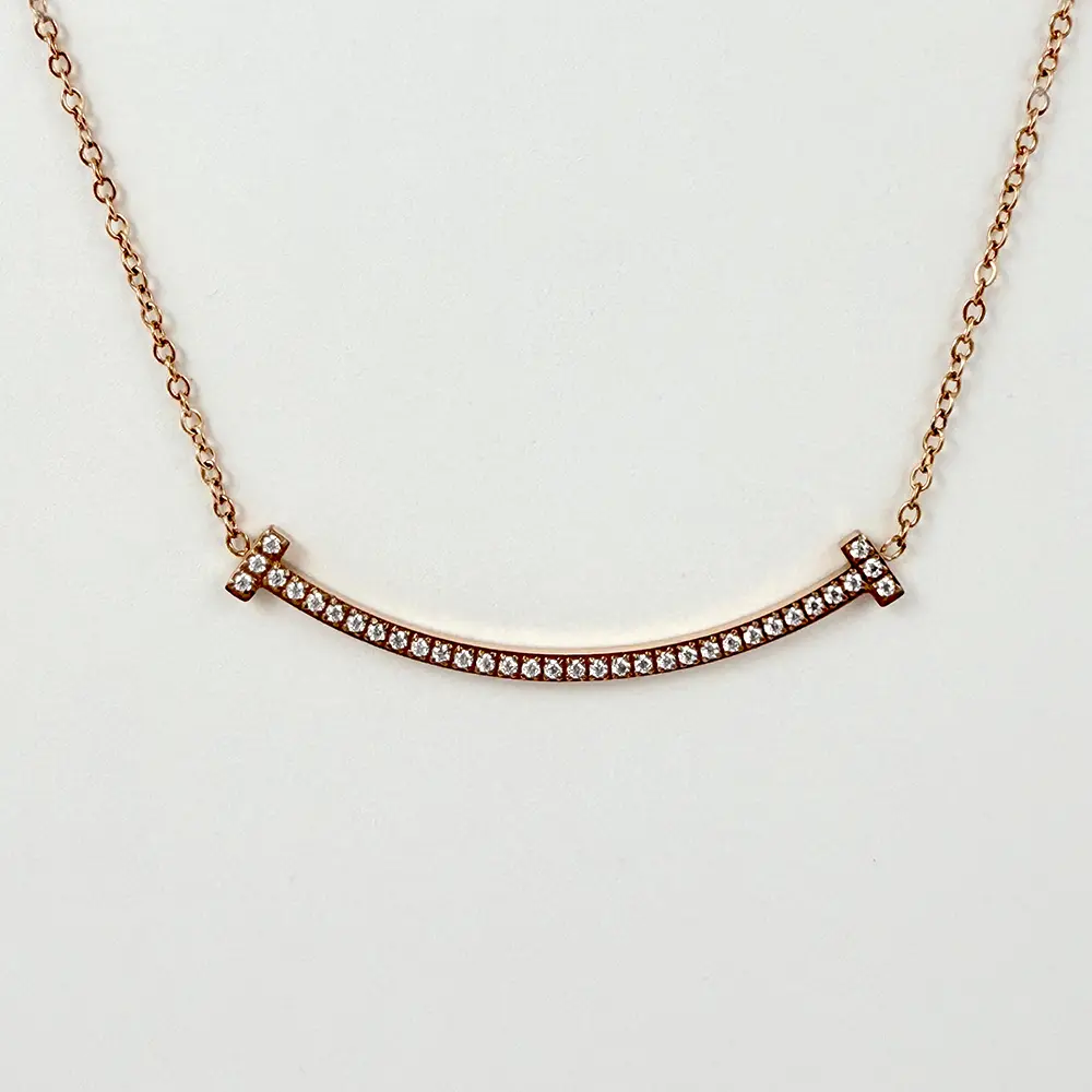 Collar en acero gold rose dije sonrisa microcircones blancos