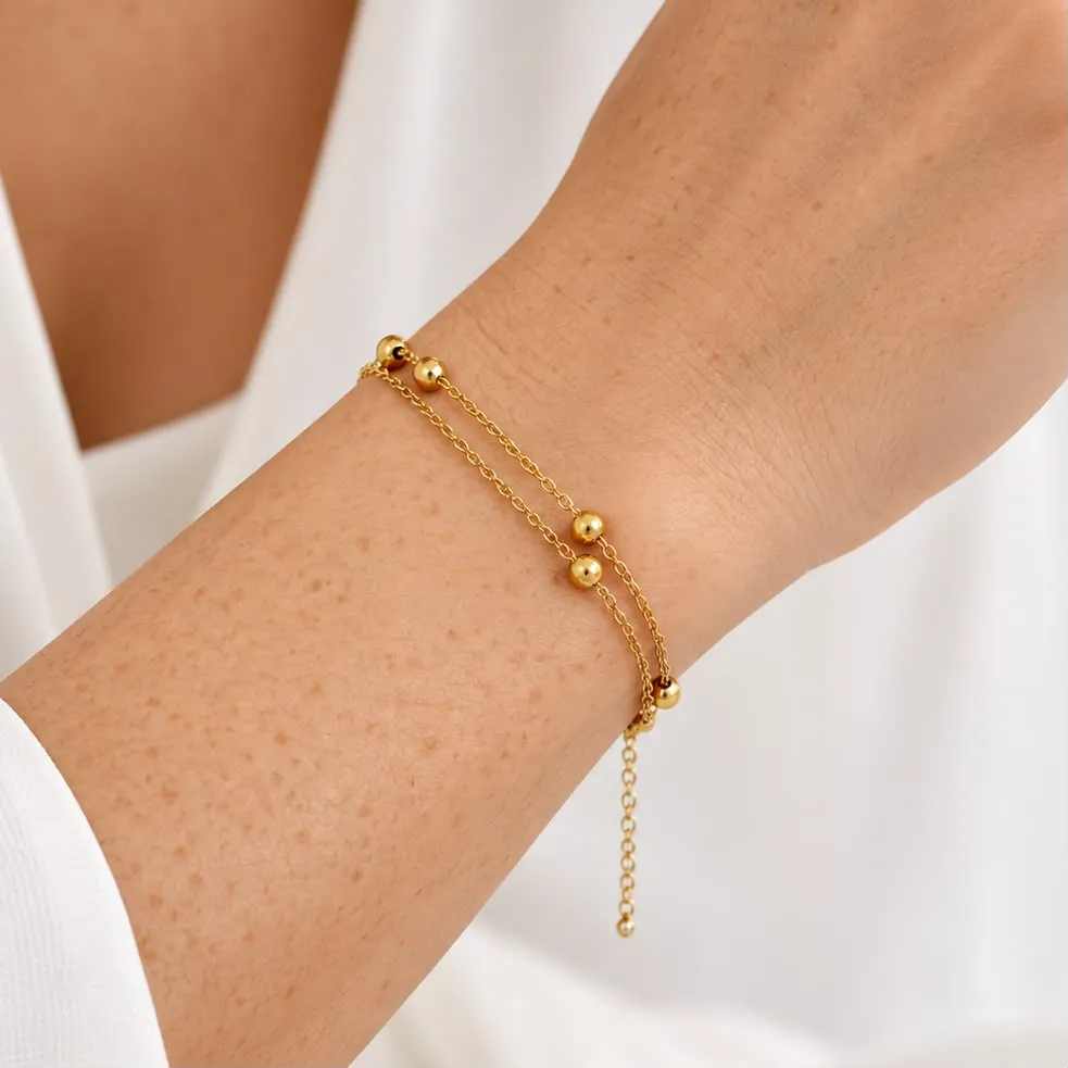 Pulsera en acero inoxidable dorada doble bolitas